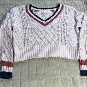 This is a crochet sweater.It has some blue white and orange stripes on the top.